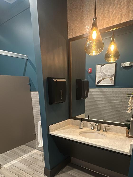Spotless commercial restroom vanity with polished counter and mirror
